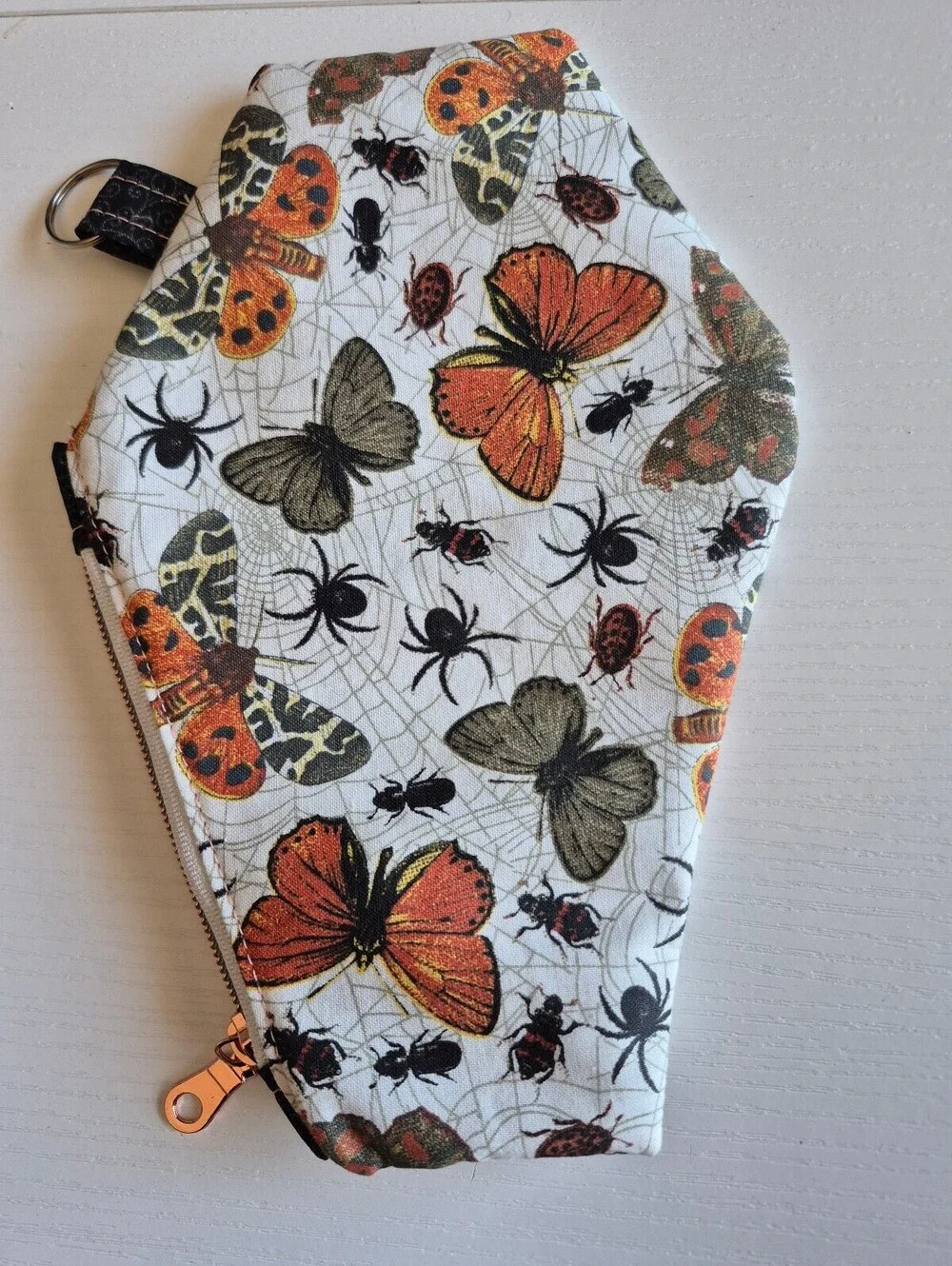 coffin pouch w/ spiders, moths, and Bettles, caught in a web in creme backing